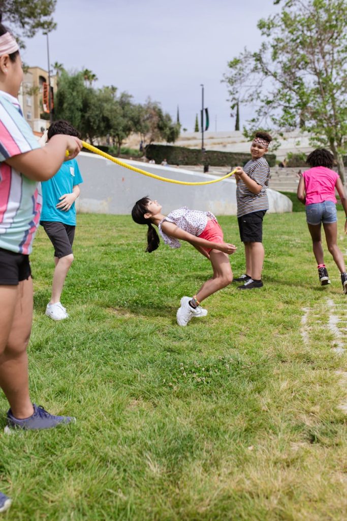 a young girl bending her body under the rope
